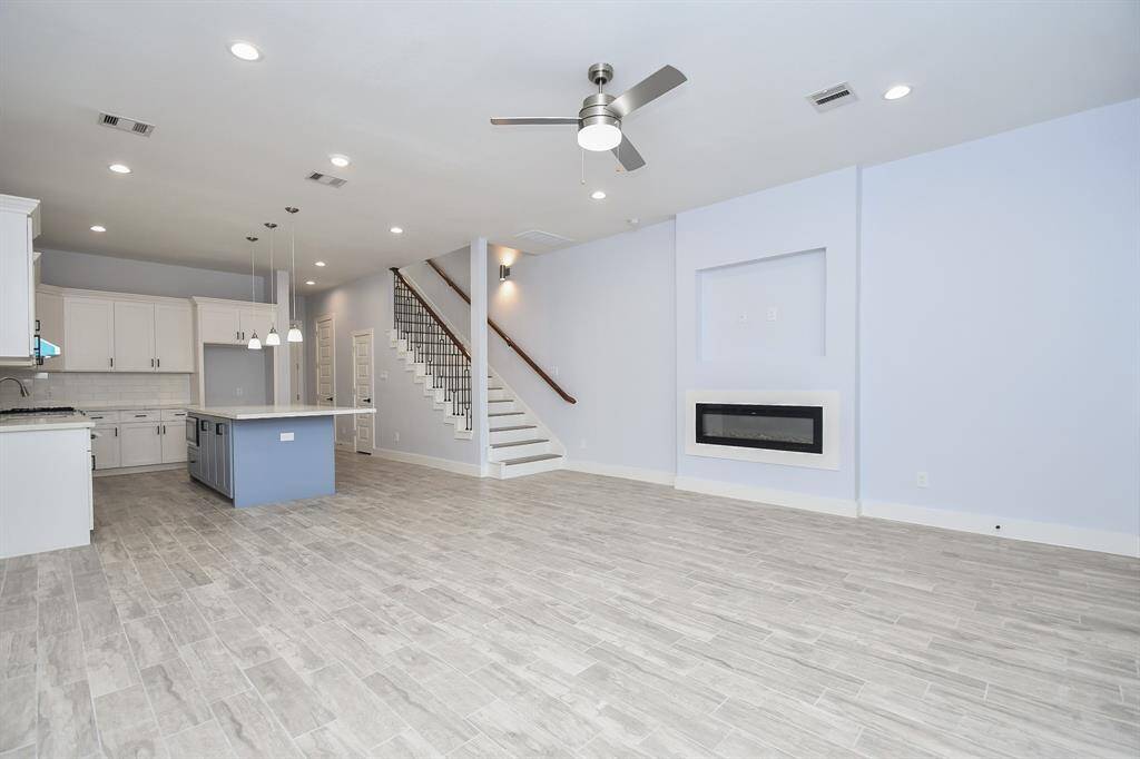 Another view of the expansive downstairs living area showcases the roomy kitchen and family room, offering an open and inviting space.