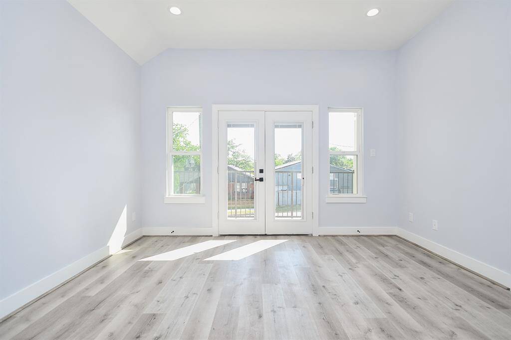 The primary bedroom offers ample space, ready for your decorating ideas, with large windows that flood the room with natural light.