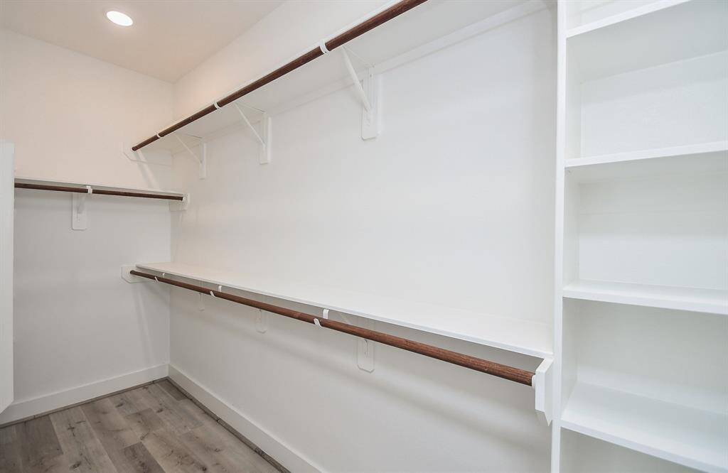 The large walk-in closet, complete with built-in shelving, perfectly complements the primary bedroom.