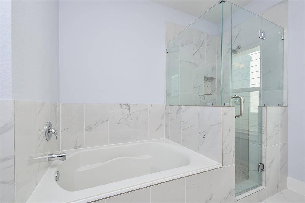 The relaxing tub and spacious walk-in shower perfectly complement the primary bedroom's en-suite, creating a serene oasis.