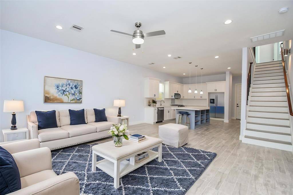 The spacious family room flows seamlessly into the well-appointed kitchen, with virtual staging offering a glimpse of the stylish potential that awaits your personal touch.