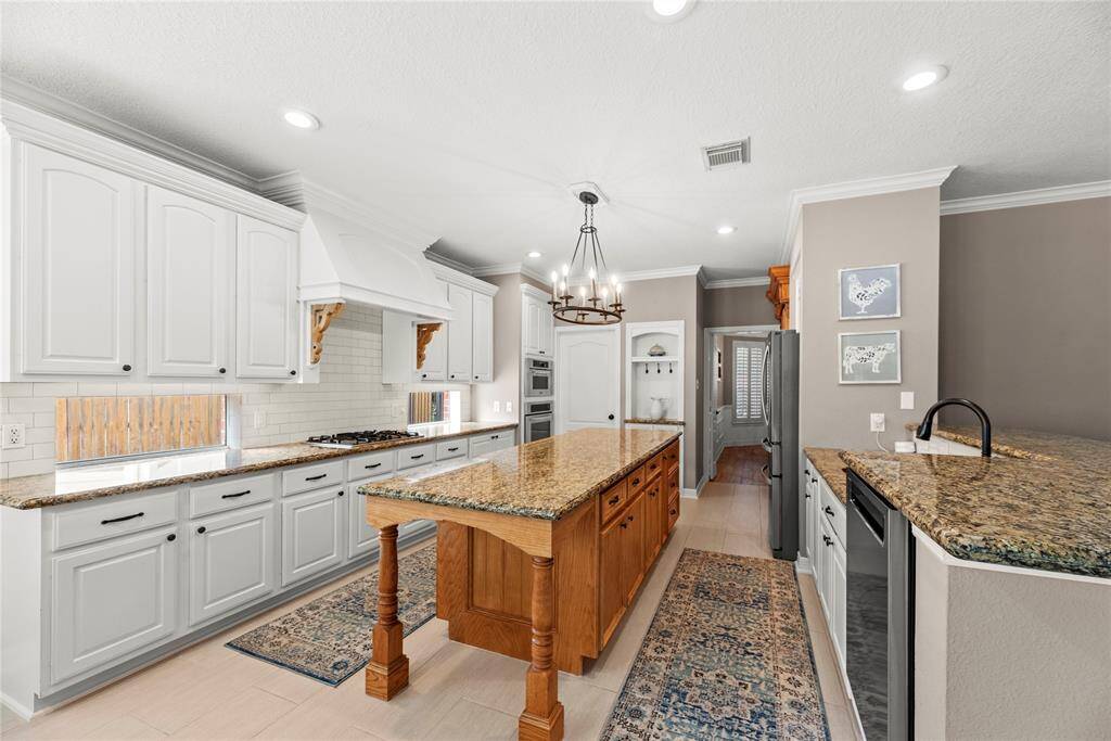 This kitchen boasts a HUGE kitchen island, subway tile backsplash, oil rubbed bronze hardware and a gorgeous light fixture to tie it all together.