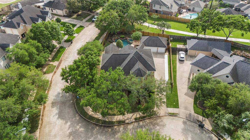This impressive aerial view showcases the prime location of this corner lot, perfectly positioned with a scenic walking path directly behind the home.