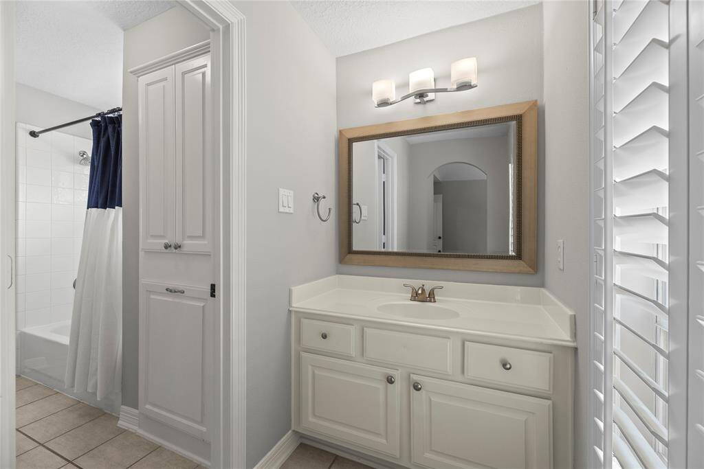 Separate from the other room is another sink, updated light fixture, and framed mirror for the last secondary bedroom upstairs.