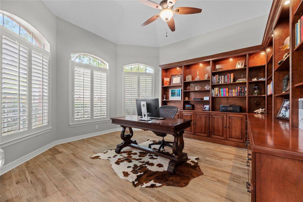 Your home office is sunlit sanctuary meets productivity powerhouse. Custom shelves, shutters, and lighting elevate your workspace.
