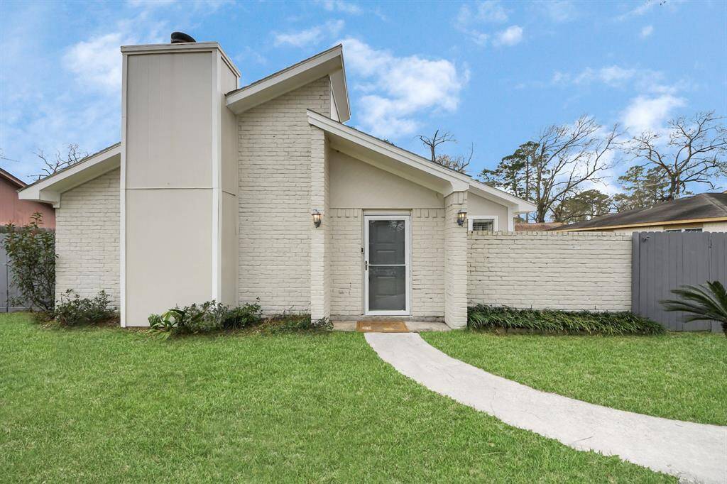 This charming home features a modern exterior with a white brick facade, a sloped roof, and a welcoming entryway. The neatly maintained lawn and pathway enhance its curb appeal, making it an inviting choice for potential buyers.