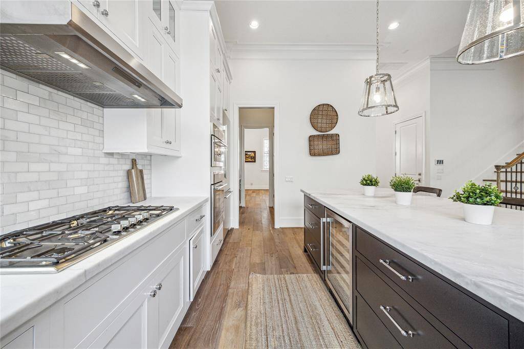 The gas cooktop has five burners and a hood vented to the outside.