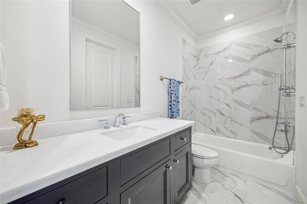 This secondary bath has an extended vanity and offers loads of storage.