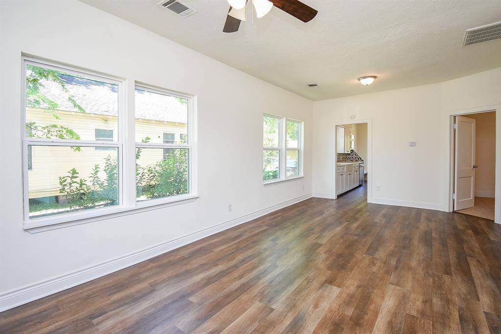 The living room boasts an abundance of windows, flooding the space with natural light and creating a bright, airy atmosphere.
