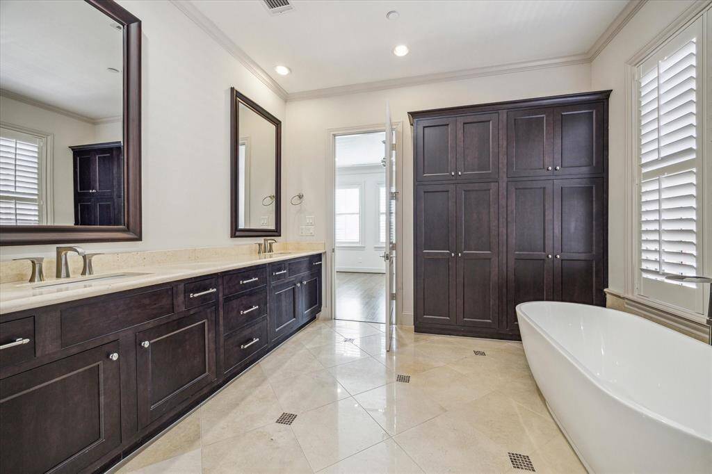 Primary bath with tremendous storage, double vanities, travertine flooring...