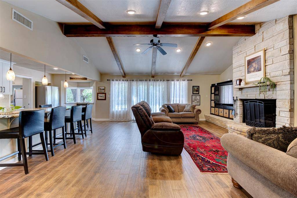 The vaulted living area blends rustic beams and ample seating including a granite bar with plenty of space for seating-for effortless entertaining,
