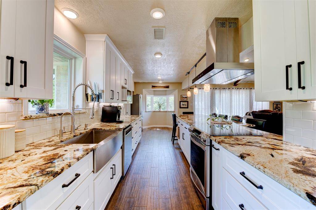 The white shaker cabinets with black hardware, pop against the granite countertops and subway tile backsplash, keeping this kitchen classic but bold. It's a clean look that still feels warm.
