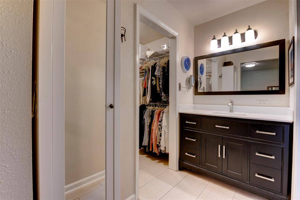 A wide mirror and updated lighting offer a modern polished look.