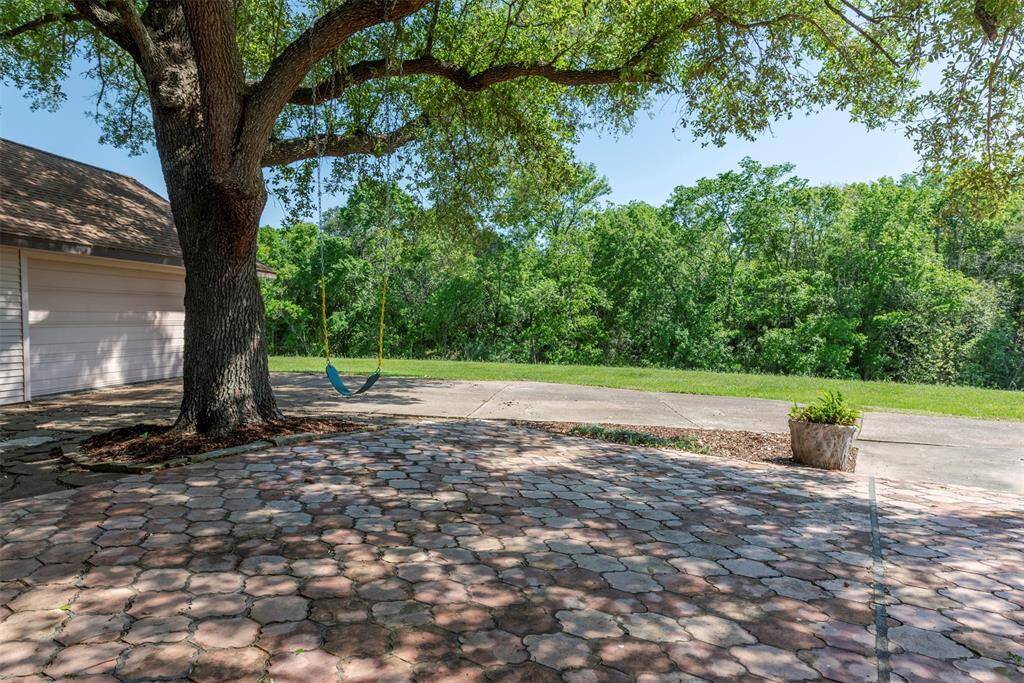 Saltillo tile patio off the den, shaded by mature trees and perfect for relaxing or entertaining. The backyard feels private and peaceful surrounded on two sides by Clear Creek with a thick tree line on the opposite bank. Great space for morning coffee, grilling or letting the kinds enjoy the swing under the tree.
