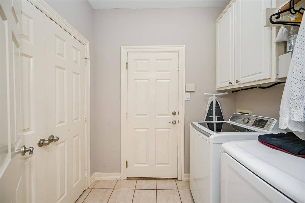 This open, airy utility room easily welcomes sizeable laundry appliances, with great storage above, and closets to fill.