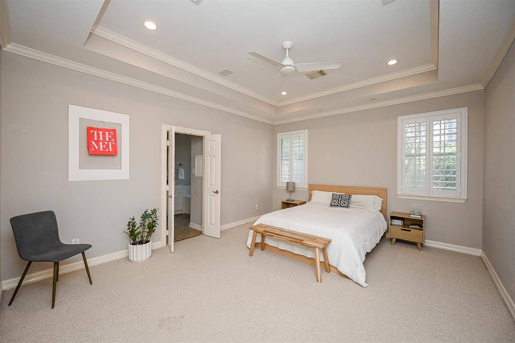 Your spacious primary suite on the 1st level welcomes your most loved bedroom pieces, of just about any size and shape. Dual windows with charming plantation shutters allow just the right amount of light you desire into this dreamy space. The handsome tray ceiling creates instant intimacy.