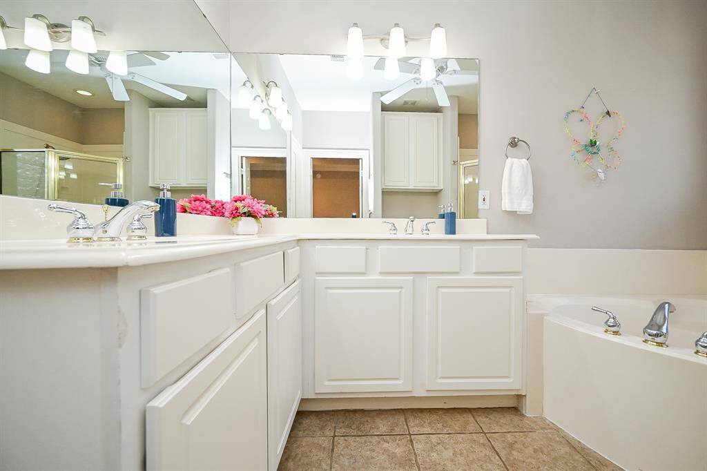 There's just something special and heart warming about a primarily white or pale toned bathroom or kitchen, for that matter. Here, your spacious primary ensuite bathroom, fits the bill!  Comfortable use of wall/floor space has been utilized to the max, to deliver convenient creature comforts; with dual sinks and shining mirrors, delicate lighting, above. Soothing wall and tile floor tones provide relaxation and refreshing options in this private oasis.