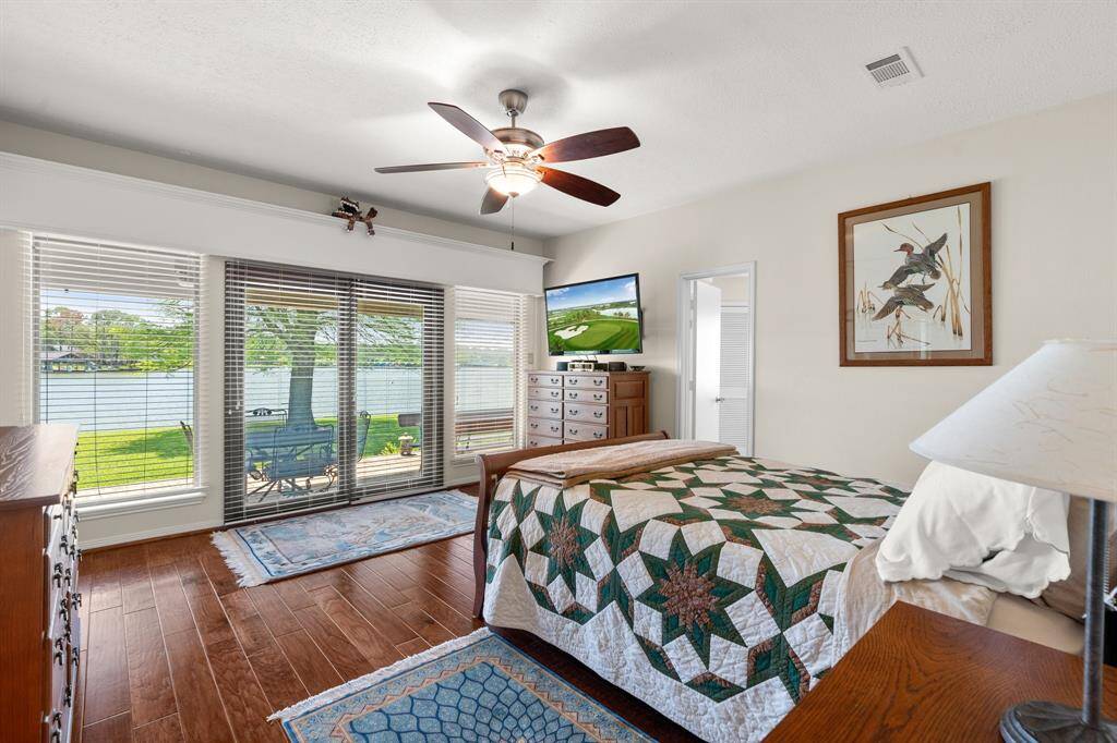 Primary bedroom features beautiful wood floors and access to the covered porch.