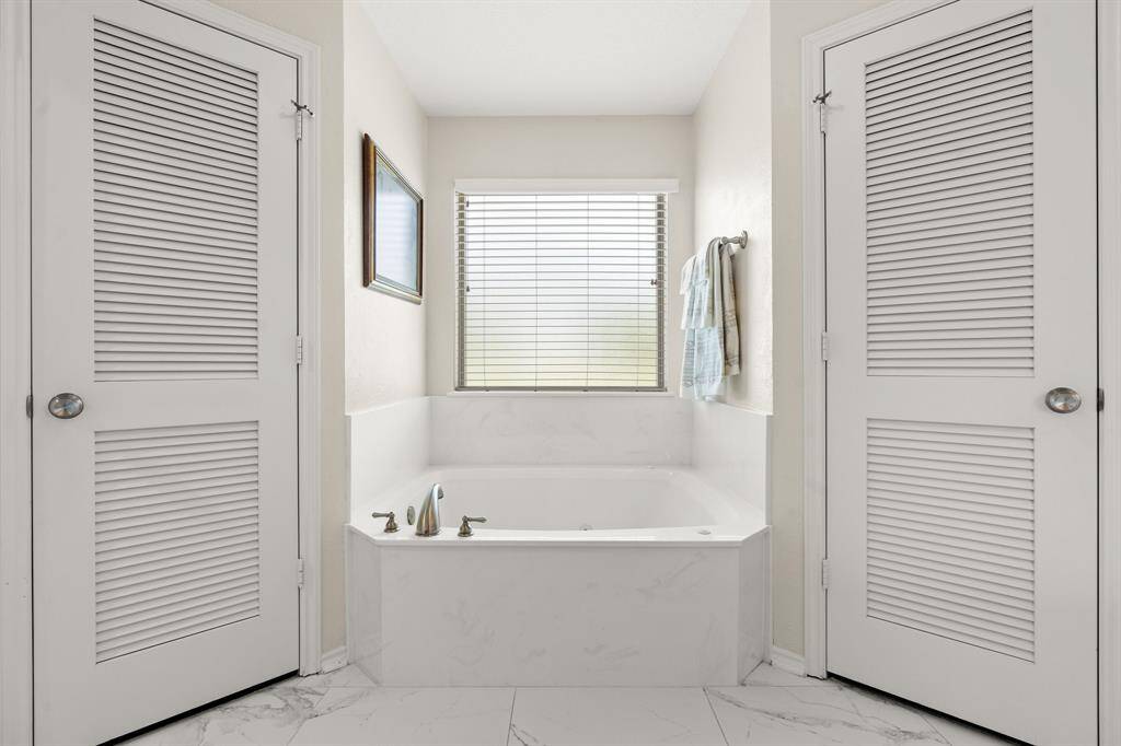 Dual closets flanking the separate tub.