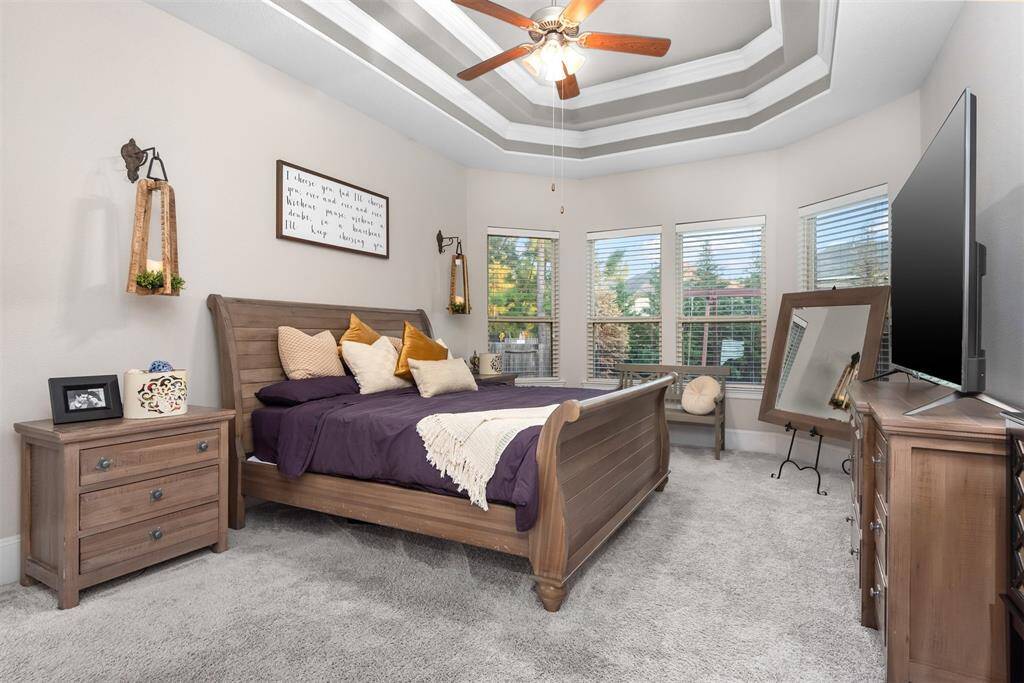 Spacious Primary Suite with recessed ceiling and bay windows.