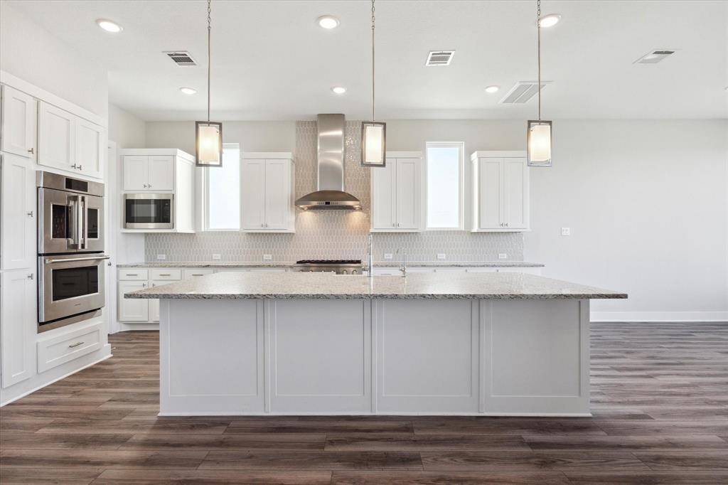 HUGE kitchen island with Quartz, counters, bar dining area and tons of cabinetry!