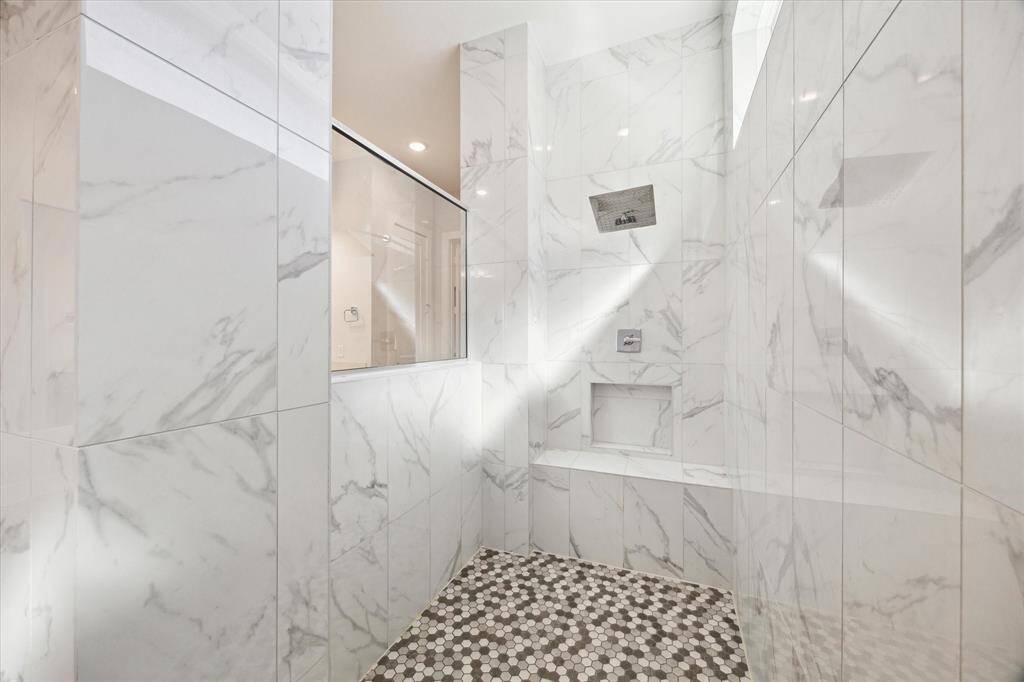 LOOK at this shower....with stone flooring, white marble floor to ceiling and comfortable seating