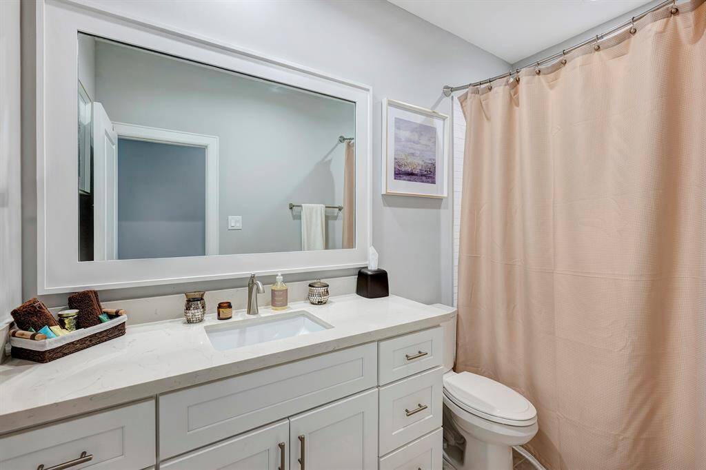 Secondary bath has quartz counters and a tub/shower