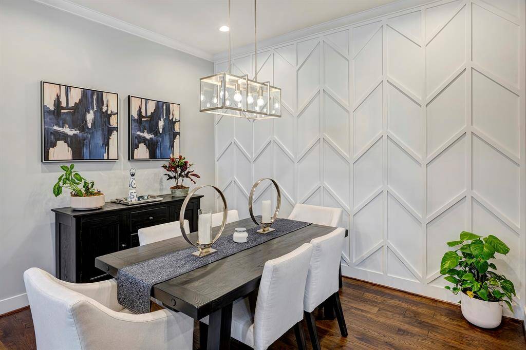 The dining room features a beautiful accent wall and engineered hardwood floors.