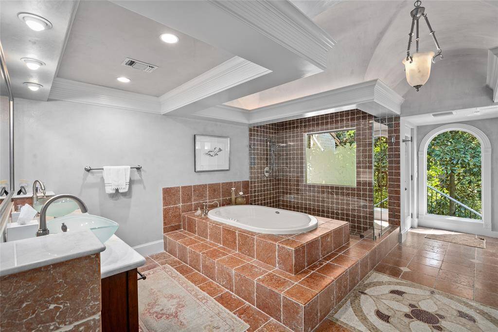 Primary bath features gorgeous terracotta tile bath and shower plus backdoor access.