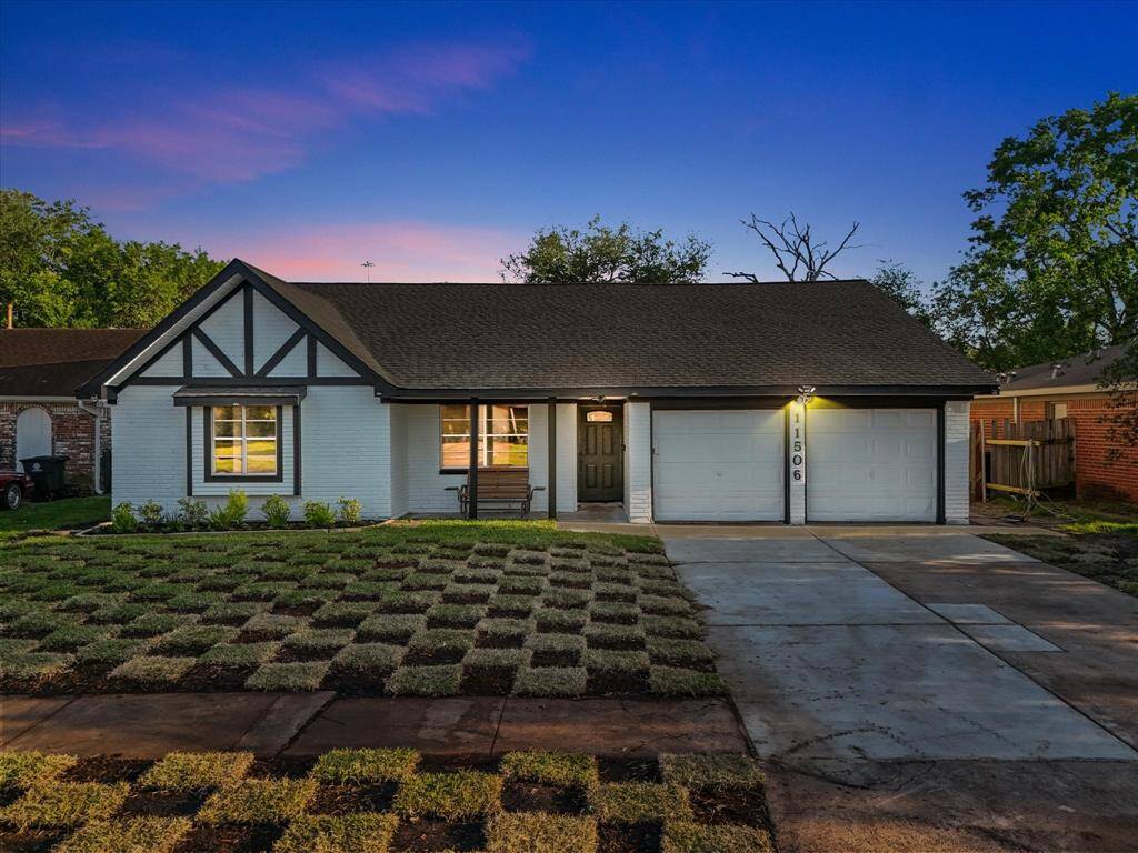 Charming single-story home with Tudor-style accents, featuring a spacious two-car garage and a newly sodded front lawn. The exterior is well-lit, offering a welcoming ambiance. The inside is equally impressive with a remastered 4 bedroom 3 bath.