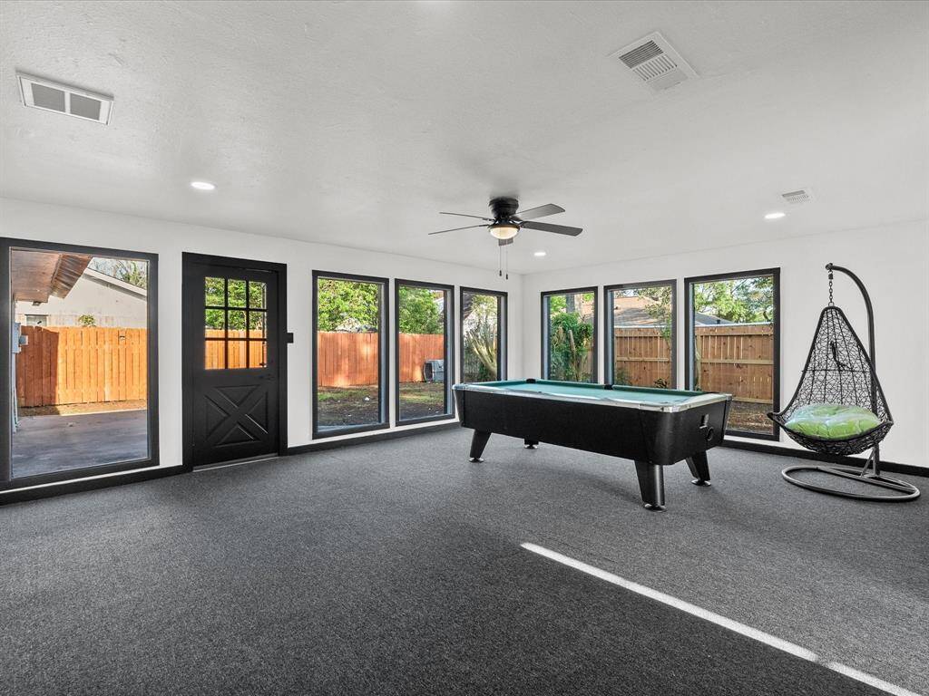 The game room/ sun room, offers plenty of natural light and ample space for entertaining and relaxation.