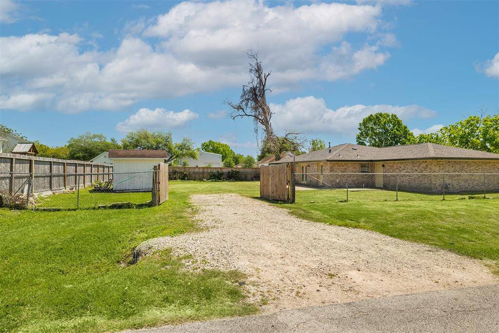 Second entrance to property with large gravel driveway and private gate.