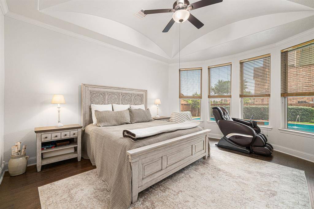 Primary bedroom has elaborate vaulted groin ceiling, hardwood floors, and large windows with gorgeous views of the backyard.