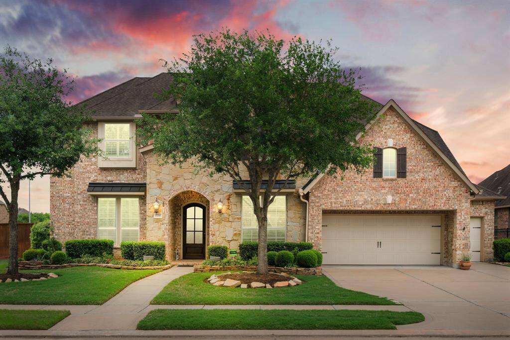Gorgeous stone and brick elevation, complete with metal roof accents and meticulous landscaping.