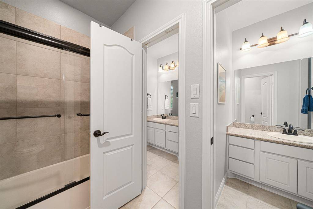 This Hollywood bathroom is between the two upstairs bedrooms and it features large vanities, and a sliding glass shower/tub combination.