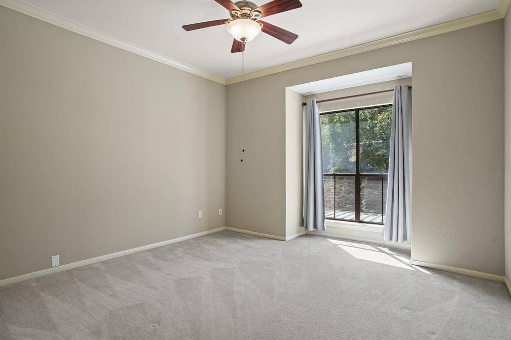 Secondary bedroom features awindow and plush carpet.