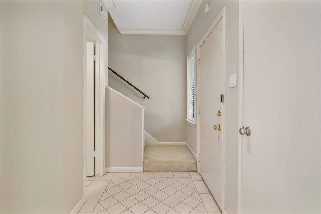 Upon entering is tile flooring and the carpeted staircase to the second floor. The door on the left is a half bath.