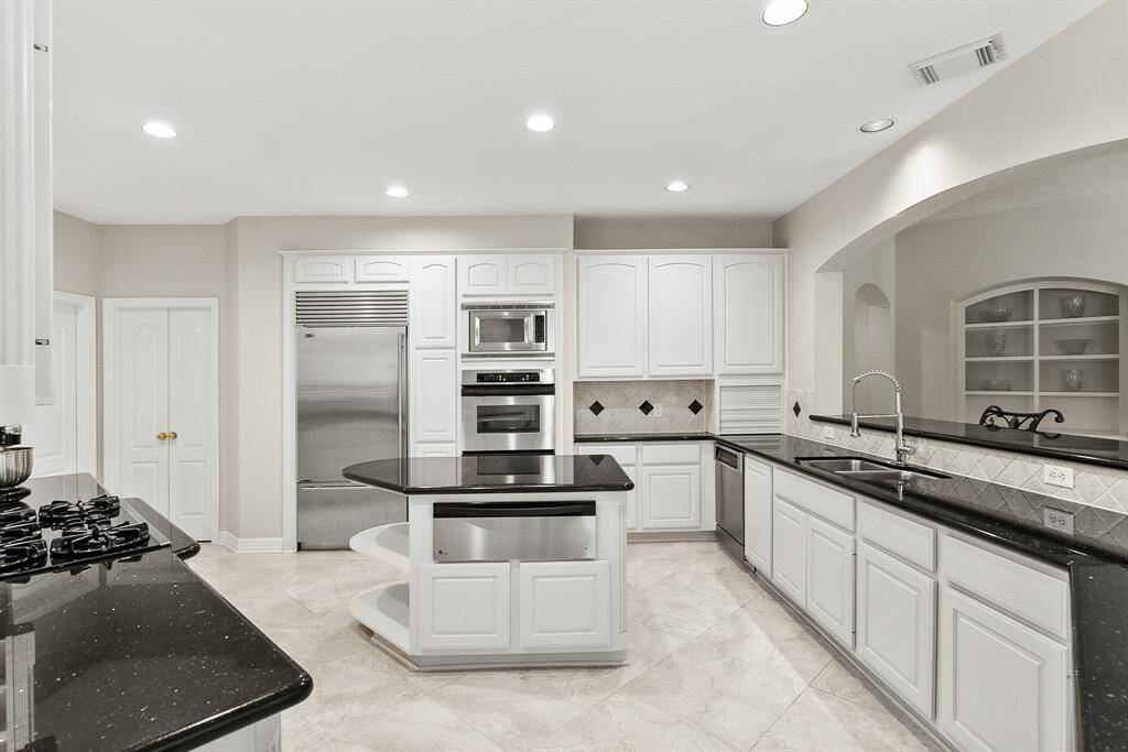 Host your next dinner party with confidence! This masterfully-equipped kitchen features a kitchen island, an abundance of cabinetry and hardware, TONS of counter space, granite countertops and stainless-steel appliances.