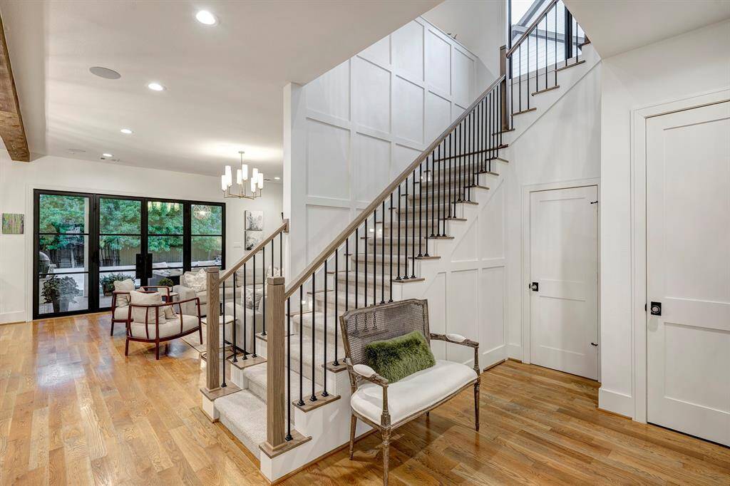 Elegant staircase with stair lighting and storage below a secret door.