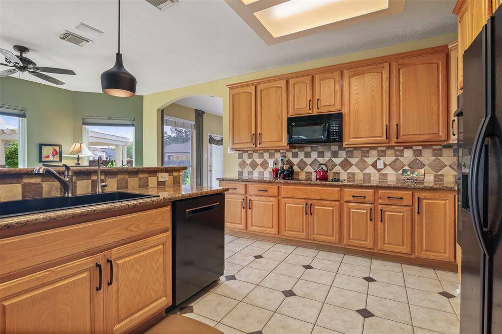 The kitchen features granite counter tops, large single composite sink and breakfast bar with custom pendant lighting.
