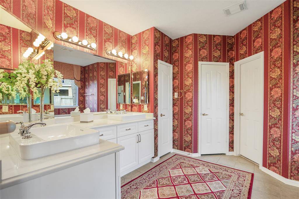 The primary bathroom features raised double sinks, linen closet, walk in closet and plenty of storage.