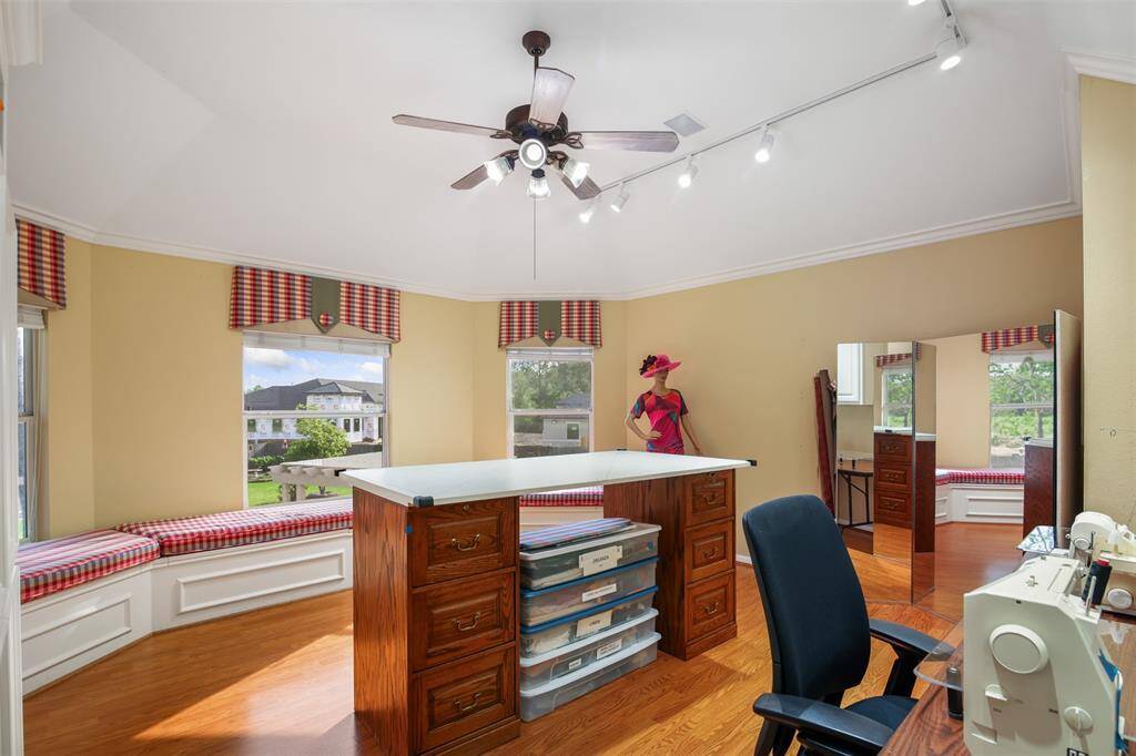 Upstairs gameroom features crown molding, wood floors, ceiling fan, tract lighting and window seats.