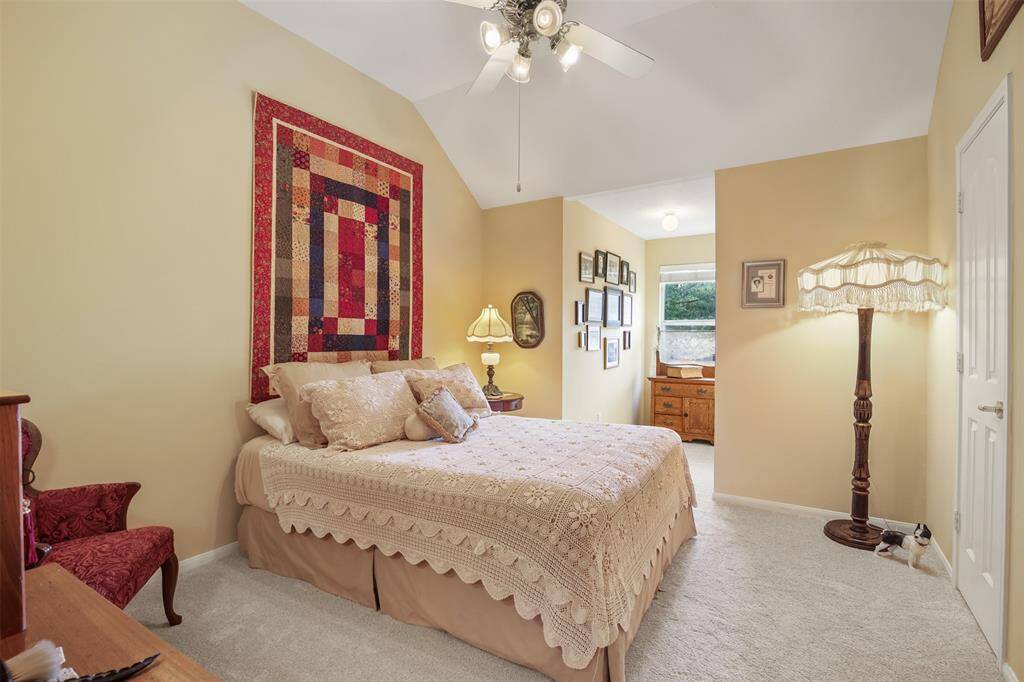 Additional secondary bedroom upstairs with carpet, ceiling fan and reading nook.