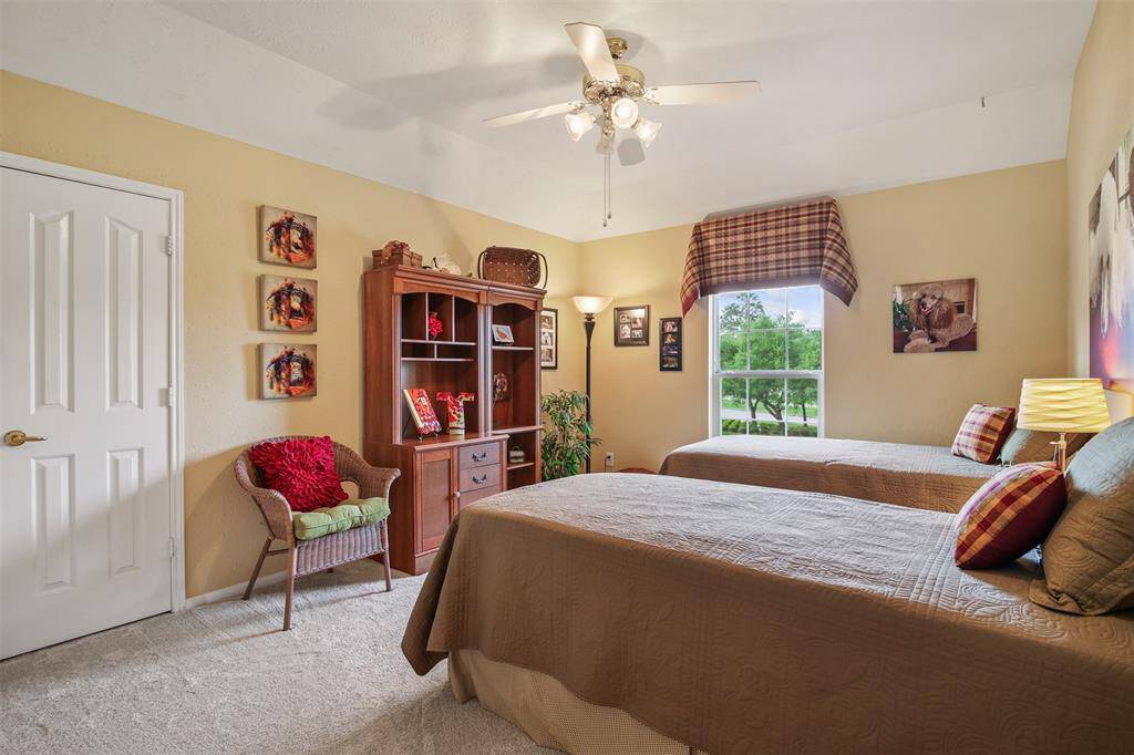 Additional secondary bedroom upstairs with carpet, ceiling fan and walk in closet.
