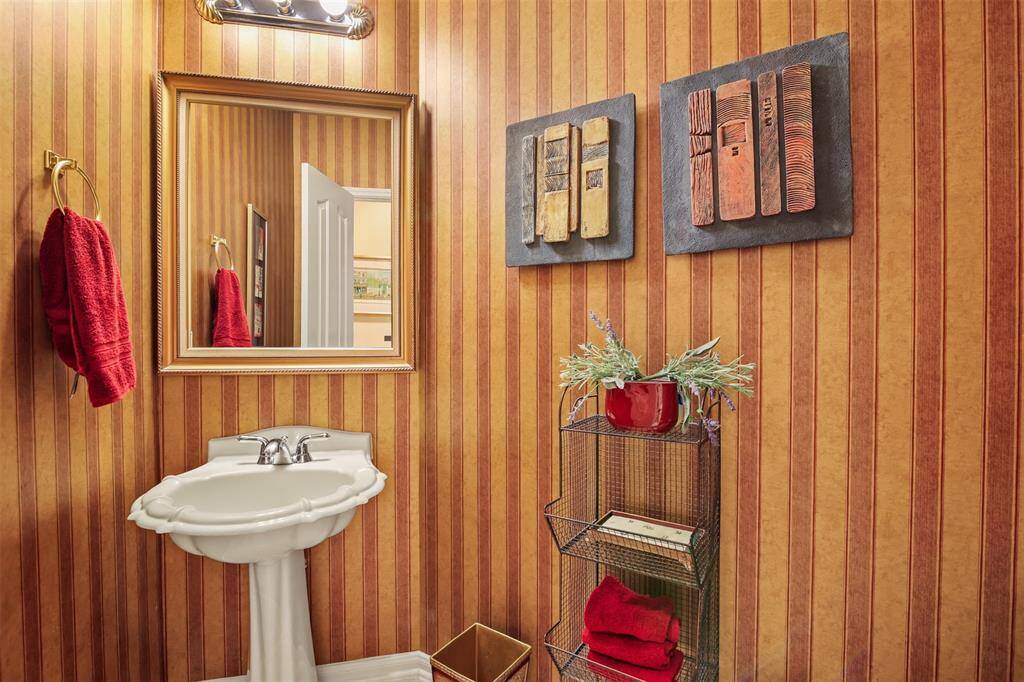 Half bathroom downstairs has a decorative pedestal sink.