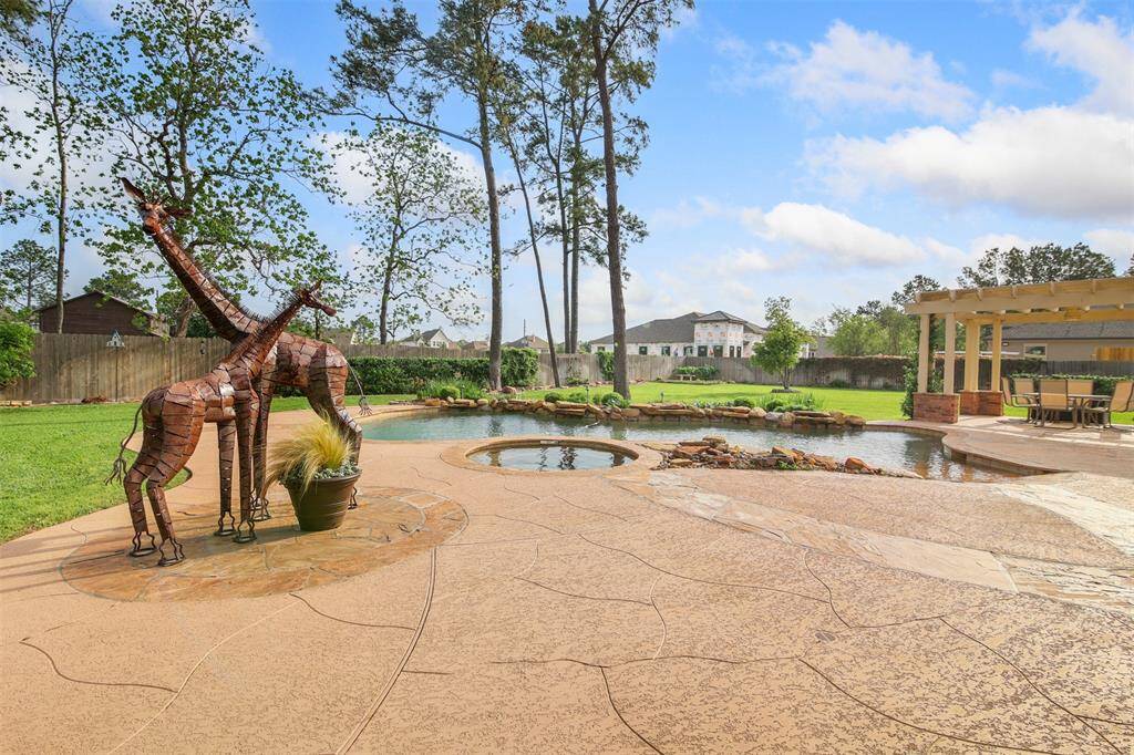 View of the backyard showcasing the large stamped decking built around the pool and extended into the yard.