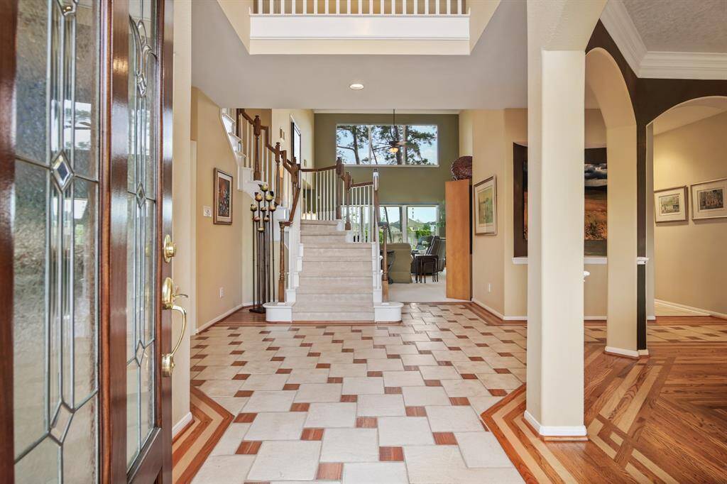 The two story front entry of the home has decorative tile flooring with wood inlay and a beautiful lead glass front door.