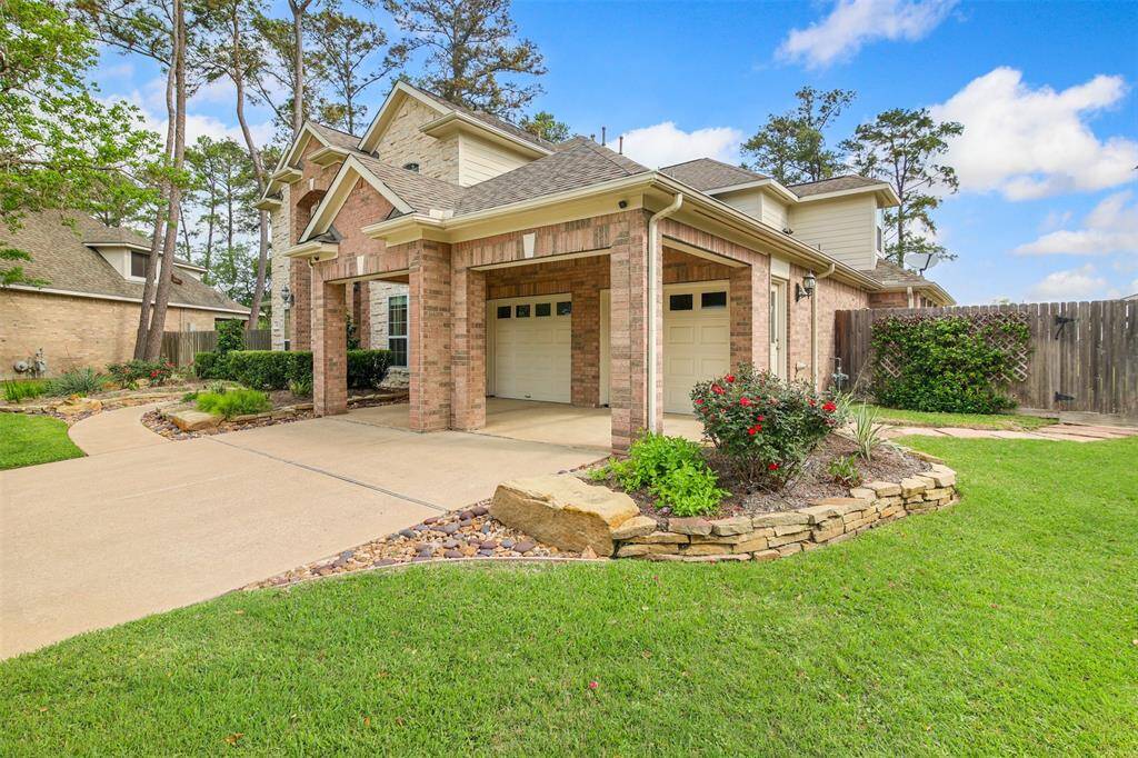 Right side of home showing porte-cochère separate garage doors and walk way leading to the front door.