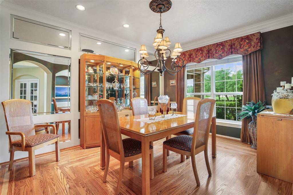 The dining room is just off the front entry and has gorgeous "real" wood floors, canned lighting and custom mirrored wall. Upgraded windows with double pane in this dining room.