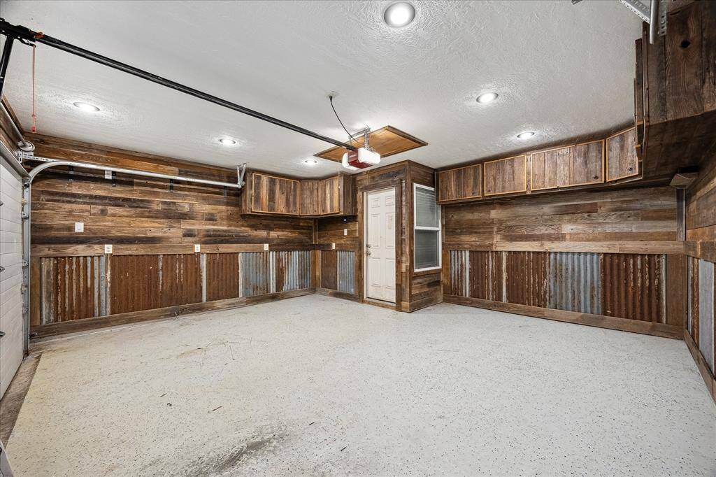 Garage features custom built shelving, plenty of storage